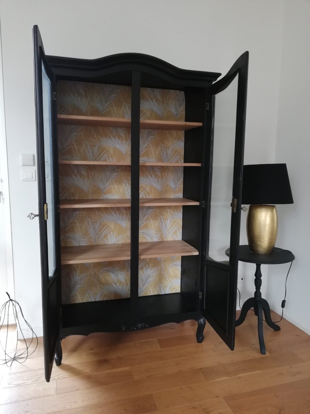 armoire vitrine noire et tapisserie